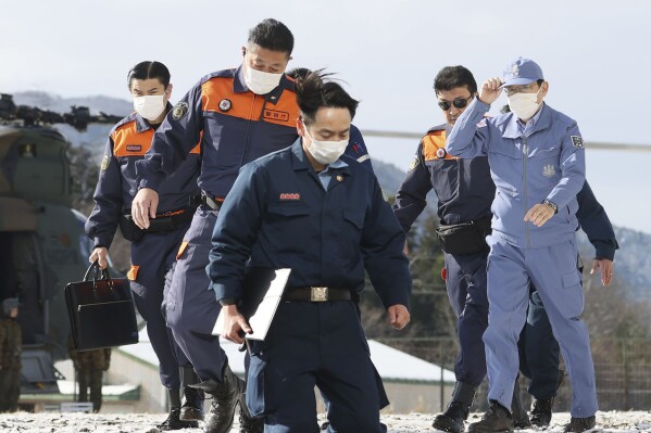 CORRECTS DATE - Japan's Prime Minister Fumio Kishida, right, arrives at a Japan Air Self-Defense Force sub base in Wajima, Ishikawa prefecture, Japan Sunday, Jan. 14, 2024. Kishida visited the country's north-central region of Noto for the first time since the Jan. 1 quakes. (Kyodo News via AP)