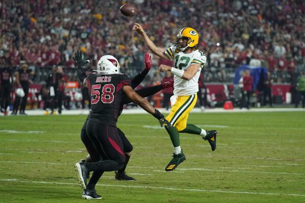 Green Bay Packers quarterback Aaron Rodgers (12) throws under pressure from Arizona Cardinals middle linebacker Jordan Hicks (58) and defensive tackle Jordan Phillips during the first half of an NFL football game, Thursday, Oct. 28, 2021, in Glendale, Ariz. (AP Photo/Rick Scuteri)