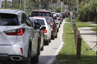 Varios automovilistas hacen fila en un sitio de pruebas diagnósticas de coronavirus el jueves 29 de julio de 2021, en Barnett Park, Orlando, Florida. (Joe Burbank/Orlando Sentinel vía AP)