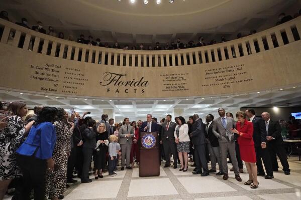 Surrounded by lawmakers, Florida Senate President Wilton Simpson speaks to members of the media after the end of a legislative session, Friday, April 30, 2021, at the Capitol in Tallahassee, Fla. (AP Photo/Wilfredo Lee)