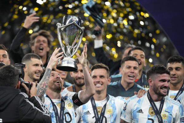 Argentina's Lionel Messi holds a trophy as he celebrates with his teammates after winning the Finalissima soccer match between Italy and Argentina at Wembley Stadium in London , Wednesday, June 1, 2022. Argentina won 3-0. (AP photo/Frank Augstein)