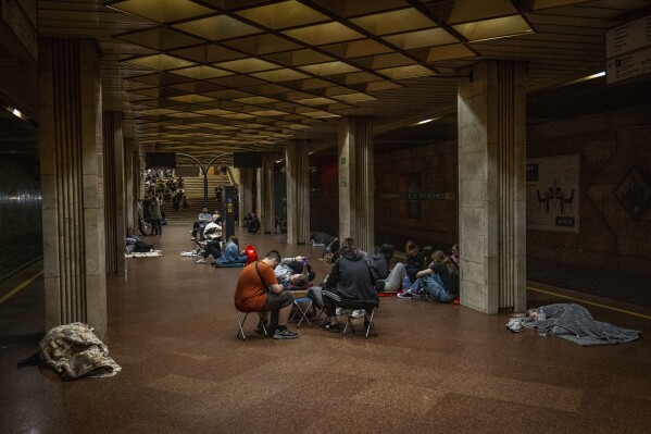People rest in a metro station, being used as a bomb shelter, during a Russian drones attack in Kyiv, Ukraine, early Friday, June 6, 2025. (AP Photo/Dan Bashakov)