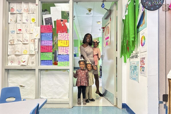 This March 2024 photo provided by The Hechinger Report shows Derrika Richard as she walks her three youngest children to their child care classrooms at Clara's Little Lambs in New Orleans. (Ariel Gilreath/The Hechinger Report via AP)