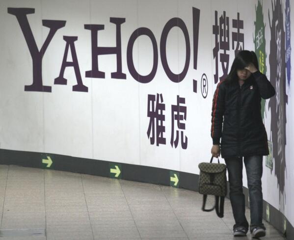 FILE - A woman walks past a Yahoo billboard in a Beijing subway in this March 17, 2006. Yahoo Inc. on Tuesday, Nov. 2, 2021 said it plans to pull out of China, citing an "increasingly challenging business and legal environment." (AP Photo, File)