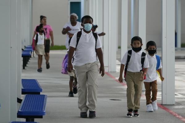 Children arrive, Tuesday, Aug. 10, 2021, for the first day of school at Washington Elementary School in Riviera Beach, Fla. (AP Photo/Wilfredo Lee)