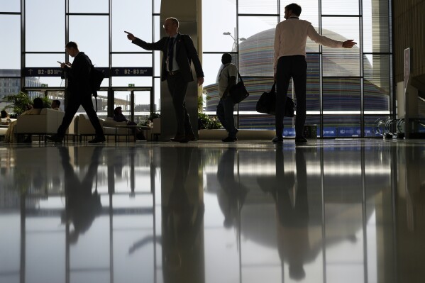 People walk through the venue at the COP28 U.N. Climate Summit, Dec. 1, 2023, in Dubai, United Arab Emirates. (AP Photo/Rafiq Maqbool)