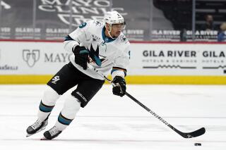 FILE - In this March 26, 2021, file photo, San Jose Sharks left wing Evander Kane moves the puck during the team's NHL hockey game against the Arizona Coyotes in Glendale, Ariz.T he NHL says it will investigate an allegation made by Kane’s wife that he bets on his own games and has intentionally tried to lose for gambling profit. (AP Photo/Rick Scuteri, File)