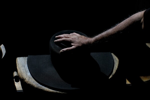Master Hatter Luis Araya shapes a hat at the “Donde Golpea el Monito” hat shop and museum that preserves a hat-making tradition dating back to 1915, in Santiago, Chile, Friday, April 4, 2025. (AP Photo/Esteban Felix)