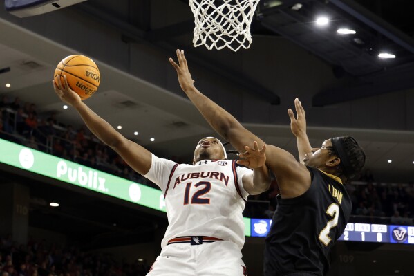 Auburn guard Denver Jones (12) is fouled by Vanderbilt forward Ven-Allen Lubin (2) as he goes for the lay up during the second half of an NCAA college basketball game, Wednesday, Jan. 31, 2024, in Auburn, Ala. (AP Photo/Butch Dill)