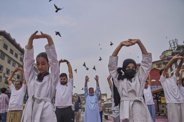 Students, along with activists of India's ruling Bharatiya Janata Party (BJP), perform yoga on International Day of Yoga at the city centre in Srinagar, Indian controlled Kashmir, Saturday, June 21, 2025. (AP Photo/Dar Yasin)