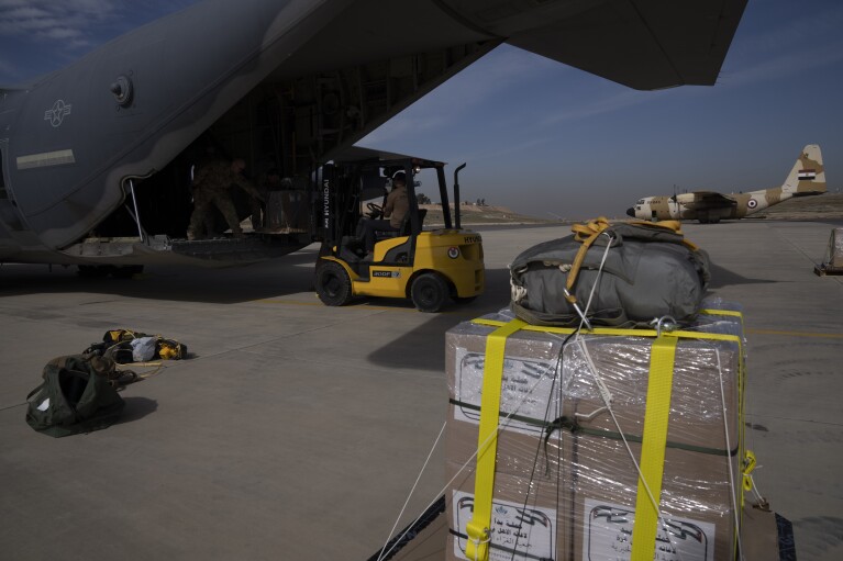 Members of the U.S. Air Force load an airplane prior to drop humanitarian aid over Gaza Strip at an area in Jordan, Thursday, March 14, 2024. (AP Photo/Leo Correa)