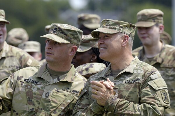 Maj. Michael Haley, right, stands and looks at the crowd during a deployment ceremony for his South Carolina National Guard unit on Saturday, June 17, 2023, in Charleston, S.C. Haley's yearlong deployment to Africa will encompass much of the campaign of his wife, former Gov. Nikki Haley, for the 2024 GOP presidential nomination. (AP Photo/Meg Kinnard)