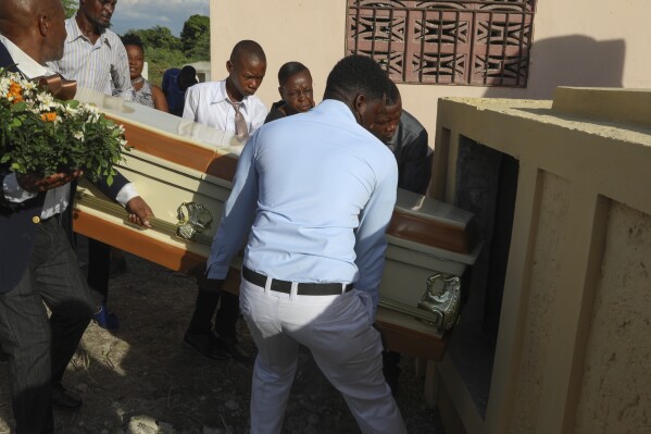 Relatives carry the coffin of Jean Louis Jeune Gracien, who was killed during an attack by armed gangs, at his funeral in Pont-Sonde, Haiti, Tuesday, Oct. 8, 2024. (AP Photo/Odelyn Joseph)