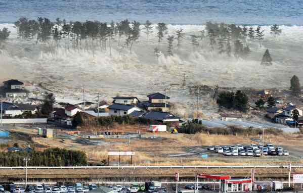 Waves of tsunami hit residences after a powerful earthquake in Natori, Miyagi prefecture (state), Japan, Friday, March 11, 2011.  The largest earthquake in Japan's recorded history slammed the eastern coast Friday. (AP Photo/Kyodo News)