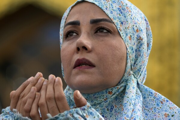 A worshipper performs an Eid al-Fitr prayer, marking the end of the Muslims' holy fasting month of Ramadan, in Tehran, Iran, on Wednesday, April 10, 2024. (AP Photo/Vahid Salemi)