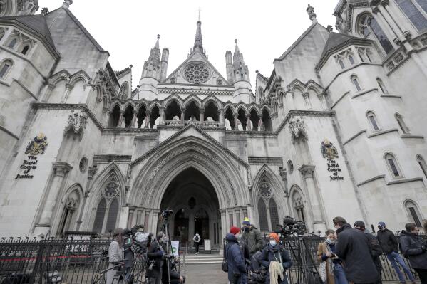 FILE - Media wait outside the High Court in London, on March 18, 2021. A British judge on Friday Jan. 20, 2023 rejected a lawsuit that accused the U.K. government of allowing the import of cotton products associated with forced labor in China’s Xinjiang region – though he said there were “widespread abuses” in the region’s cotton industry. (AP Photo/Kirsty Wigglesworth, File)