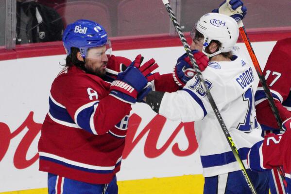 Montreal Canadiens defenseman Ben Chiarot (8) and Tampa Bay Lightning right wing Barclay Goodrow (19) throw punches after a stop in play during the third period of Game 4 of the NHL hockey Stanley Cup final in Montreal, Monday, July 5, 2021. (Paul Chiasson/The Canadian Press via AP)