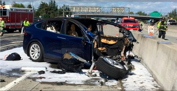 FILE - In this March 23, 2018, file photo provided by KTVU, emergency personnel work a the scene where a Tesla electric SUV crashed on U.S. Highway 101 in Mountain View, Calif. The National Transportation Safety Board says the driver was playing a video game on his smartphone at the time. (KTVU-TV via AP, File)