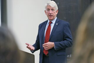 FIL - In this Wednesday Oct. 4, 2017 file photo, Virginia Attorney General Mark Herring talks with University of Richmond students at the school in Richmond, Va. Herring has filed a new lawsuit over opioids even as the attorneys general in some states are pushing to settle with companies that make or distribute the powerful painkillers. (AP Photo/Steve Helber)