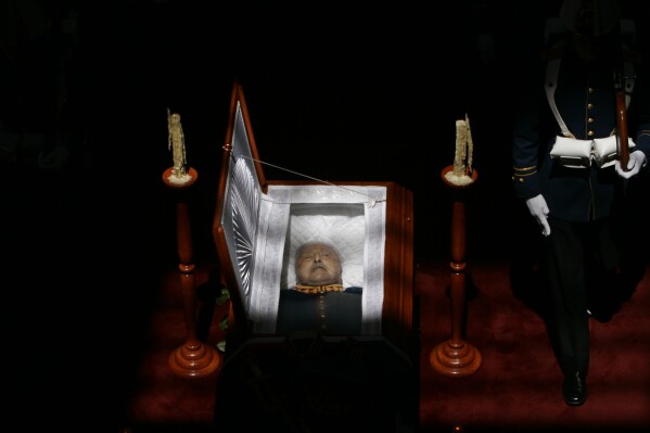 The open casket of late military ruler Gen. Augusto Pinochet is on display during his wake at the Military School in Santiago, Chile, Dec. 11, 2006. Pinochet, who ruled Chile from 1973 to 1990 after a military coup, died from heart complications at the age of 91. (AP Photo/Marco Ugarte)