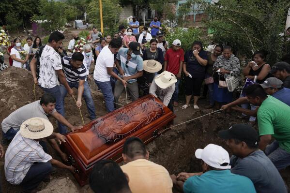 Residents bury Wilmer Rojas the day after he was killed in a mass shooting in San Miguel Totolapan, Mexico, Thursday, Oct. 6, 2022. Gunmen burst into a town hall meeting and shot to death 20 people, including a mayor and his father, officials said Thursday. (AP Photo/Eduardo Verdugo)