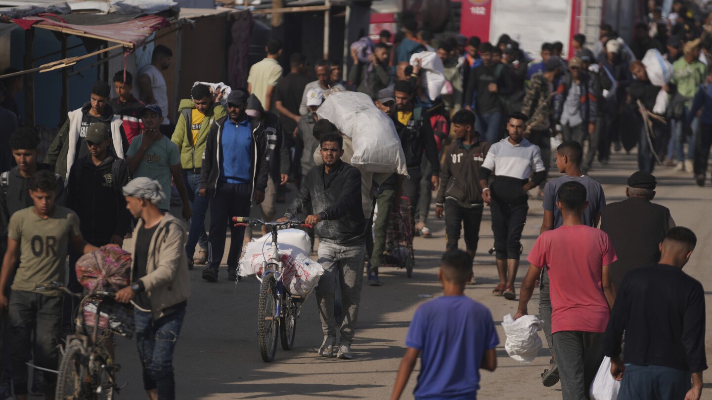 Palestinians carry bags containing food and humanitarian aid packages delivered by the Gaza Humanitarian Foundation, a U.S.-backed organization approved by Israel in Khan Younis, southern Gaza Strip, Sunday, June 1, 2025. (AP Photo/Abdel Kareem Hana)