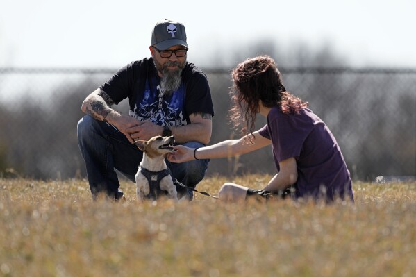 Dusty Farr talks with his transgender daughter in a park near Smithville, Mo., Sunday, Feb. 25, 2024. Farr is suing the Platt County School District after his daughter was suspended for using the girl's bathroom at the Missouri high school she attended. (AP Photo/Charlie Riedel)