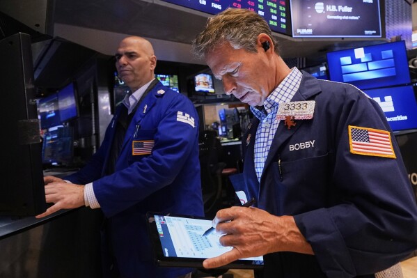 Specialist Philip Finale, left, and trader Robert Charmak work on the floor of the New York Stock Exchange, Friday, May 2, 2025. (AP Photo/Richard Drew)