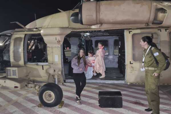 FILE - Aviv Asher, 2.5 years old, her sister Raz Asher, 4.5 years old, and mother Doron, returned to Israel on Friday, Nov. 24, 2023. A four-day cease-fire in the Israel-Hamas war began in Gaza on Friday with an exchange of hostages and prisoners. The phrase 