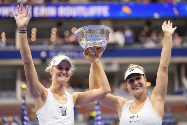 Erin Routliffe, of New Zealand, left, and Gabriela Dabrowski, of Canada, hold up the championship trophy after winning the women's doubles final of the U.S. Open tennis championships against Laura Siegemund, of Germany, and Vera Zvonareva, of Russia, Sunday, Sept. 10, 2023, in New York. (AP Photo/Manu Fernandez)