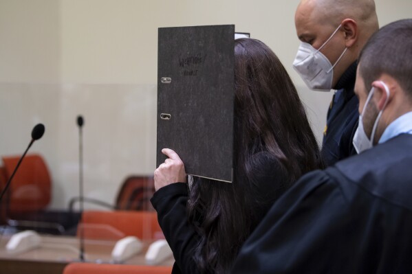 FILE - Defendant Jennifer W. arrives in a courtroom for her trial in Munich, Germany, Oct. 25, 2021. A German federal court said Wednesday it has rejected the woman's appeal against her 14-year sentence for allowing a 5-year-old Yazidi girl she and her husband kept as a slave when they were members of the Islamic State group in Iraq to die of thirst in the sun. (Sven Hoppe/dpa via AP, File)