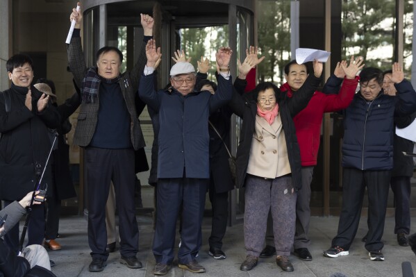 Family members of victims react outside the Supreme Court of Korea in Seoul, South Korea, Thursday, Dec. 28, 2023. South Korea’s top court on Thursday ordered a third Japanese company to compensate some of its former wartime Korean employees for forced labor, the second such ruling in a week. (Yun Dong-jin/Yonhap via AP)