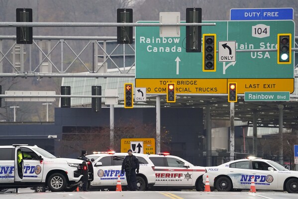 Law enforcement personnel block off the entrance to the Rainbow Bridge, Wednesday, Nov. 22, 2023, in Niagara Falls, N.Y. The border crossing between the U.S. and Canada has been closed after a vehicle exploded at a checkpoint on a bridge near Niagara Falls. The FBI's field office in Buffalo said in a statement that it was investigating the explosion on the Rainbow Bridge, which connects the two countries across the Niagara River. (Derek Gee/The Buffalo News via AP)
