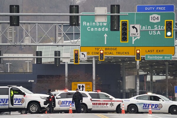 Personal encargado de hacer cumplir la ley bloquea la entrada al Puente Arcoíris, el miércoles 22 de noviembre de 2023, en las Cataratas del Niágara, Nueva York. El cruce fronterizo entre Estados Unidos y Canadá se cerró después de que un vehículo explotara en un puesto de control en un puente cerca de las Cataratas del Niágara.  La oficina de campo del FBI en Buffalo dijo en un comunicado que estaba investigando la explosión en el Puente Arcoíris, que conecta los dos países a través del río Niágara.  (Derek Gee/The Buffalo News vía AP)