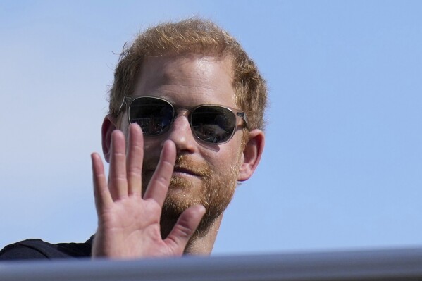 FILE - Britain's Prince Harry, The Duke of Sussex, waves during the Formula One U.S. Grand Prix auto race at Circuit of the Americas, on Oct. 22, 2023, in Austin, Texas. Prince Harry was not improperly stripped of his publicly funded security detail during visits to Britain after he gave up his status as a working member of the royal family and moved to the U.S., a London judge ruled Wednesday Feb. 28, 2024. (AP Photo/Nick Didlick, File)