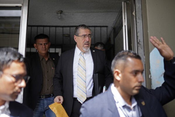 President-elect Bernardo Arevalo leaves his Congressional office surrounded by his security detail in Guatemala City, Thursday, Nov. 16, 2023. Guatemalan prosecutors said Thursday they will seek to strip Arevalo and several members of his party of their immunity for allegedly making social media posts that encouraged students to take over a public university in 2022. Arevalo is expected to be inaugurated in Jan. 2024. (AP Photo/Santiago Billy)