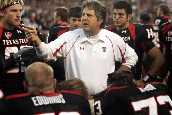 FILE - Texas Tech head coach Mike Leach talks with his team in the second quarter of an NCAA college football game against Texas A&M in Lubbock, Texas, Saturday, Oct. 24, 2009. Mike Leach, the gruff, pioneering and unfiltered college football coach who helped revolutionize the passing game with the Air Raid offense, has died following complications from a heart condition, Mississippi State said Tuesday, Dec. 13, 2022. He was 61. (AP Photo/Mike Fuentes, File)