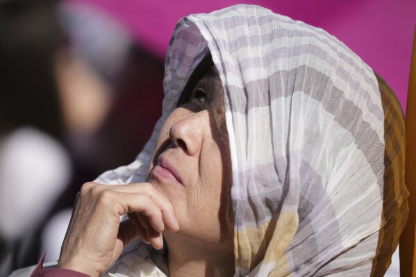 A woman looks up during the conclave to elect a new pope, in St. Peter's Square, at the Vatican, Thursday, May 8, 2025. (AP Photo/Andrew Medichini)