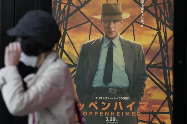 A person walks by a poster to promote the movie "Oppenheimer" Friday, March 29, 2024, in Tokyo. (AP Photo/Eugene Hoshiko)