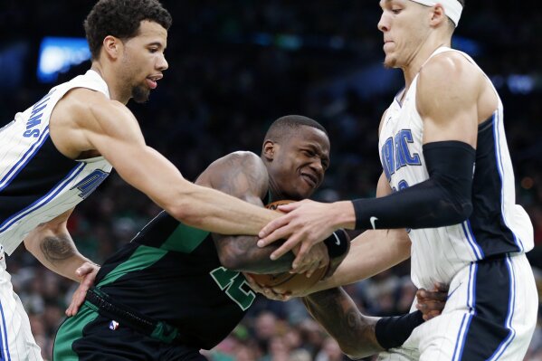 
              Boston Celtics' Terry Rozier (12) struggles to control the ball against Orlando Magic's Michael Carter-Williams, left, and Aaron Gordon during the first half of an NBA basketball game in Boston, Sunday, April 7, 2019. (AP Photo/Michael Dwyer)
            
