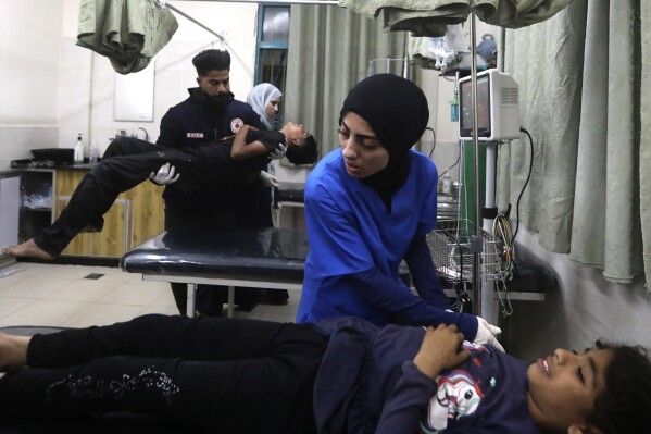 Palestinian medics treat a wounded person as the other one carries a young wounded in the Israeli bombardment of the Gaza Strip at the Kuwaiti Hospital in Rafah refugee camp, southern Gaza Strip, early Friday, May 3, 2024. (AP Photo/Ismael Abu Dayyah)