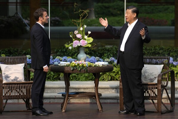 FILE - Chinese President Xi Jinping, right, and France's President Emmanuel Macron talk prior to a tea ceremony at the Guandong province governor's residence in Guangzhou, China, on April 7, 2023. French President Emmanuel Macron will seek to press China's Xi Jinping to use his influence to move Russia toward ending the war in Ukraine during a two-day state visit to France. Both leaders were also expected to discuss trade disputes over electric cars, cognac and cosmetics. (AP Photo/Thibault Camus, Pool, File)