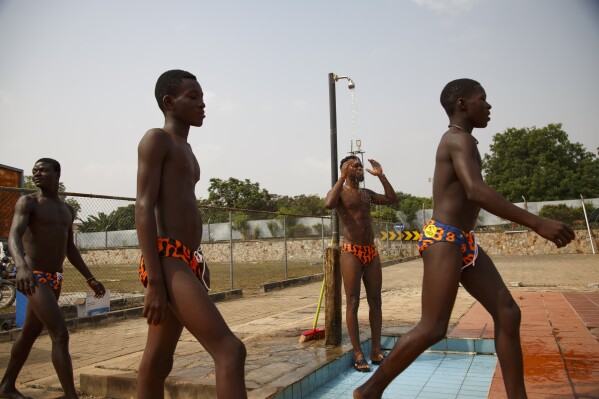 Participants in the Black Star Polo competition, held at the University of Ghana in Accra, Saturday, Jan. 14, 2023, shower before their game. The Awutu Winton Water Polo Club has seven teams representing three regions of Ghana. Former water polo pro Prince Asante is training young players in the sport in his father's homeland of Ghana, where swimming pools are rare and the ocean is seen as dangerous. (AP Photo/Misper Apawu)