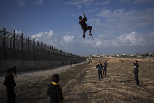 Palestinians displaced by the Israeli bombardment of the northern Gaza Strip play next to the border with Egypt, in Rafah, southern Gaza, Sunday, Jan. 14, 2024. (APPhoto/Fatima Shbair, File)