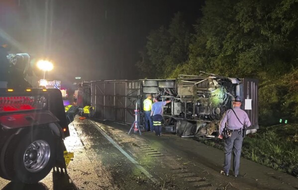 Police and rescue workers arrive on the scene of a bus crash late Sunday, Aug. 6, 2023, in Lower Paxton Township, Dauphin County ,Pa. The crash occurred between a passenger vehicle and charter bus carrying up to 50 passengers causing multiple fatalities and injuries. (Pennsylvania State Police via AP)