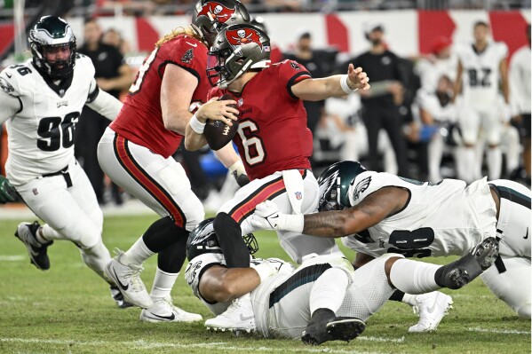 Tampa Bay Buccaneers' Baker Mayfield (6) is tackled by Philadelphia Eagles' Jalen Carter (98) and Marlon Tuipulotu (95) during the first half of an NFL football game, Monday, Sept. 25, 2023, in Tampa, Fla. (AP Photo/Jason Behnken)