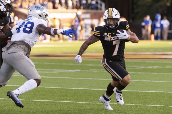 Missouri running back Cody Schrader (7) runs past Middle Tennessee's James Stewart, left, during the first quarter of an NCAA college football game Saturday, Sept. 9, 2023, in Columbia, Mo. (AP Photo/L.G. Patterson)