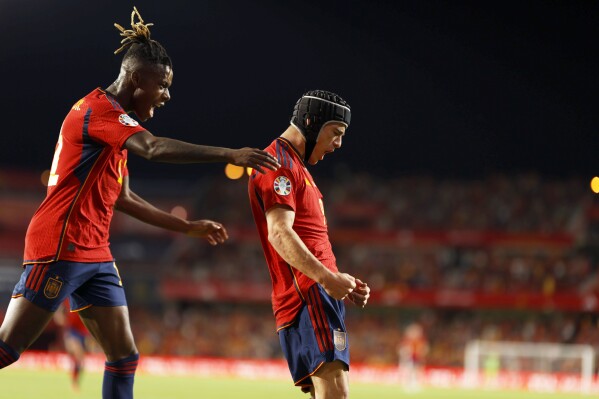 Spain's Gavi celebrates, with Nico Williams, left, after scoring the opening goal during the Euro 2024 group A qualifying soccer match between Spain and Cyprus in Granada, Spain, Tuesday, Sept. 12, 2023. (AP Photo/Fermin Rodriguez)
