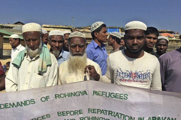 
              In this Jan. 20, 2018, photo, a group of Rohingya refugees hold banner that show a list of demand before Bangladesh and Myanmar governments start the process of repatriation, at Kutupalong refugee camp, near Cox's Bazar, Bangladesh. With the first repatriations of Rohingya refugees back to Myanmar just days away, and more than 1 million living in refugee camps in Bangladesh, international aid workers, local officials and the refugees say preparations have barely begun  and most refugees would rather contend with the squalor of the camps than the dangers they could face if they return home. It's unclear if more than a handful of Rohingya will even be willing to go home.  (AP Photo/Rishabh R. Jain)
            