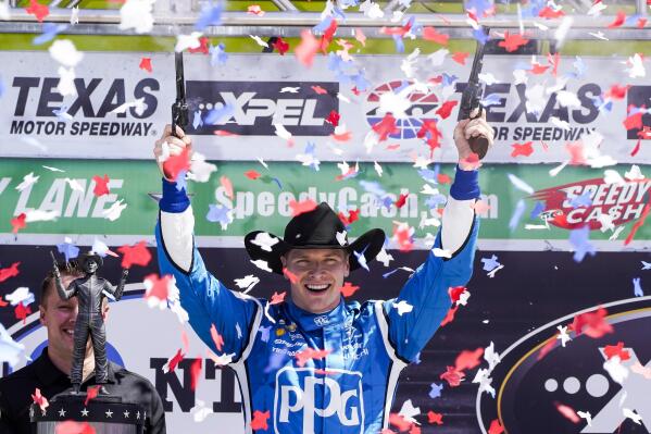 Josef Newgarden fires two six-shooters up into the air after winning the NTT IndyCar Series XPEL 375 at Texas Motor Speedway in Fort Worth, Texas, Sunday, March 20, 2022. (AP Photo/Larry Papke)